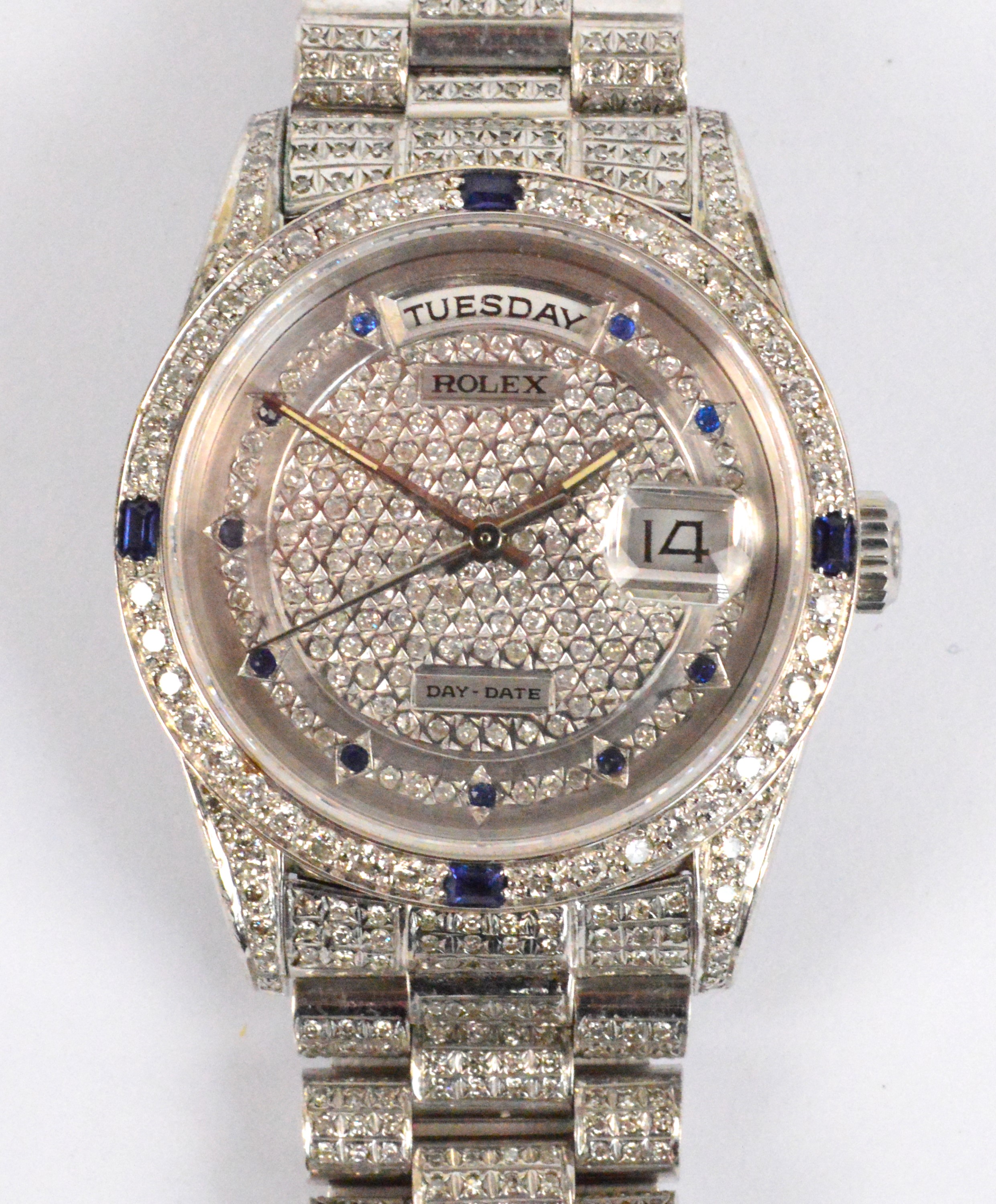 ROLEX; an 18ct white gold day/date wristwatch with diamonds and sapphires set throughout.