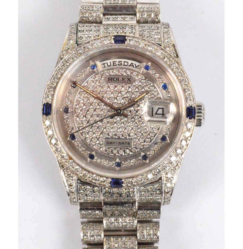 ROLEX; an 18ct white gold day/date wristwatch with diamonds and sapphires set throughout.