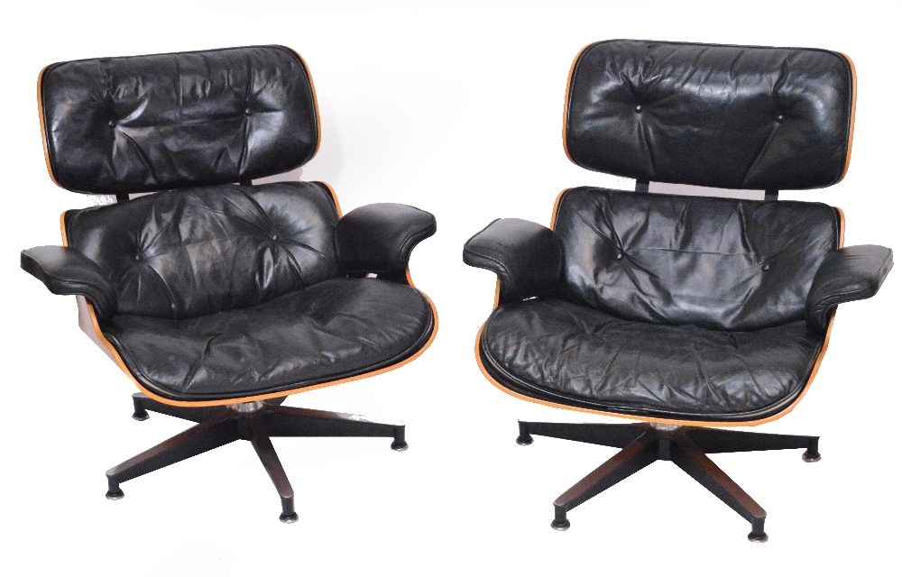 CHARLES AND RAY EAMES FOR HERMAN MILLER; a pair of Charles and Ray Eames for Herman Miller rosewood veneered and black leather upholstered lounge chairs.