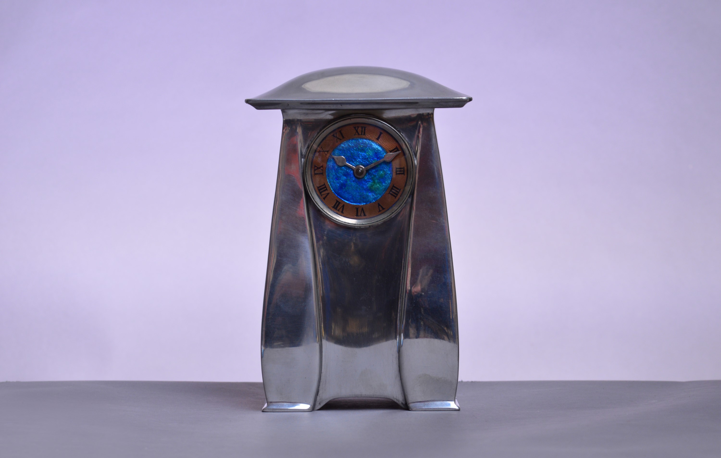 ARCHIBALD KNOX FOR LIBERTY & CO; a Tudric polished pewter mantel timepiece.