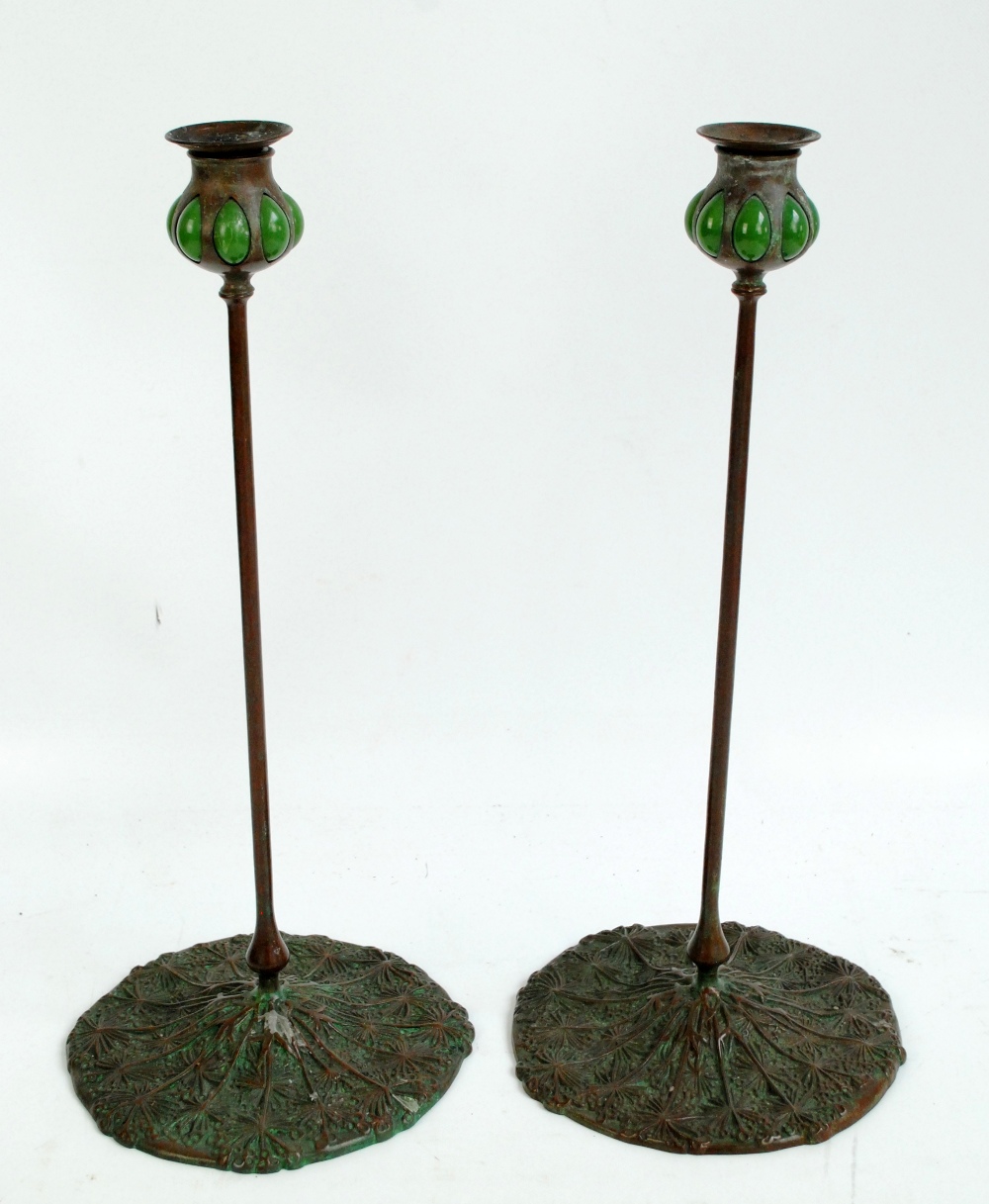 TIFFANY STUDIOS, NEW YORK (1899-1918); a pair of patinated bronze and Favrile glass tall candlesticks.