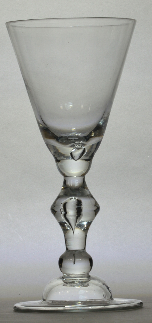 A large early 18th century heavy baluster goblet with wide round funnel bowl above cusp knop set with a tear above domed folded foot, English c.1710, height 25.5cm.